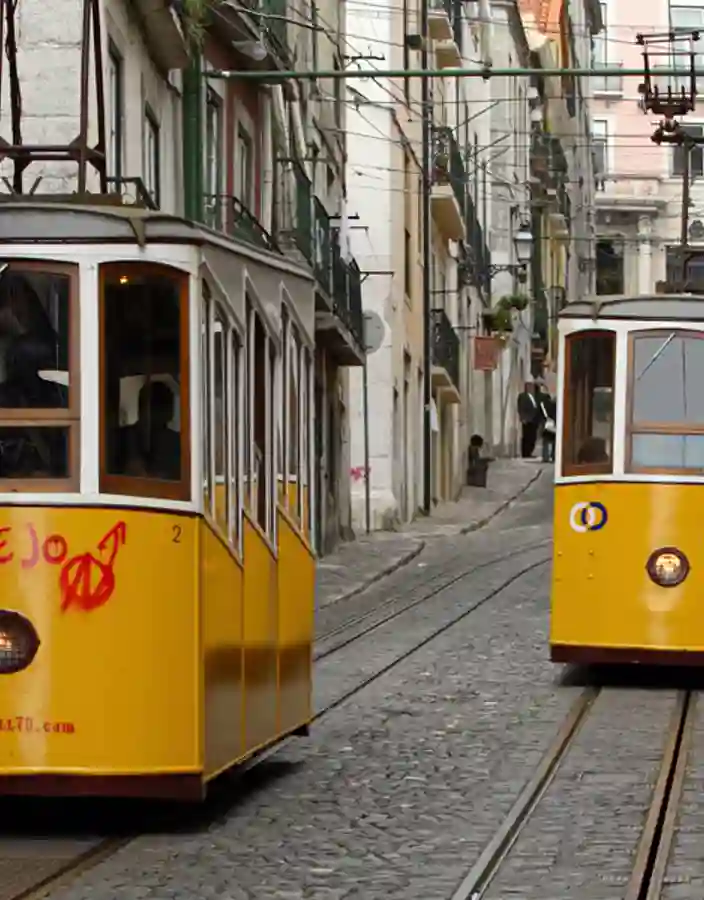 Gula spårvagnar i smala gränder i Lissabon