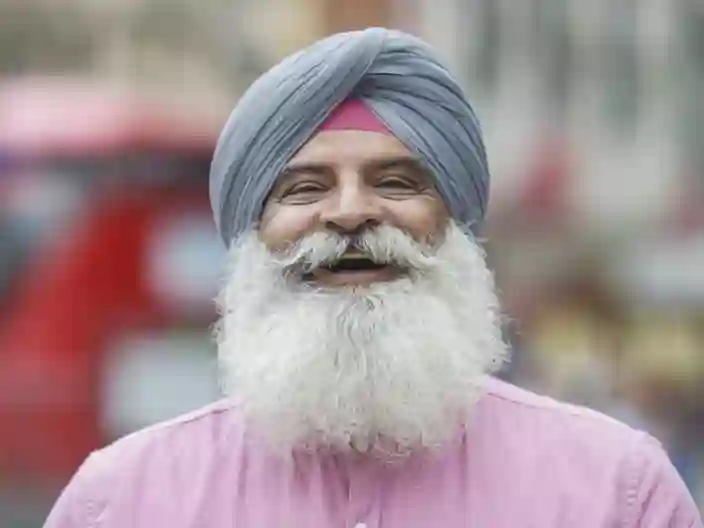 Portræt af ældre indisk mand i turban, smilende på gaden