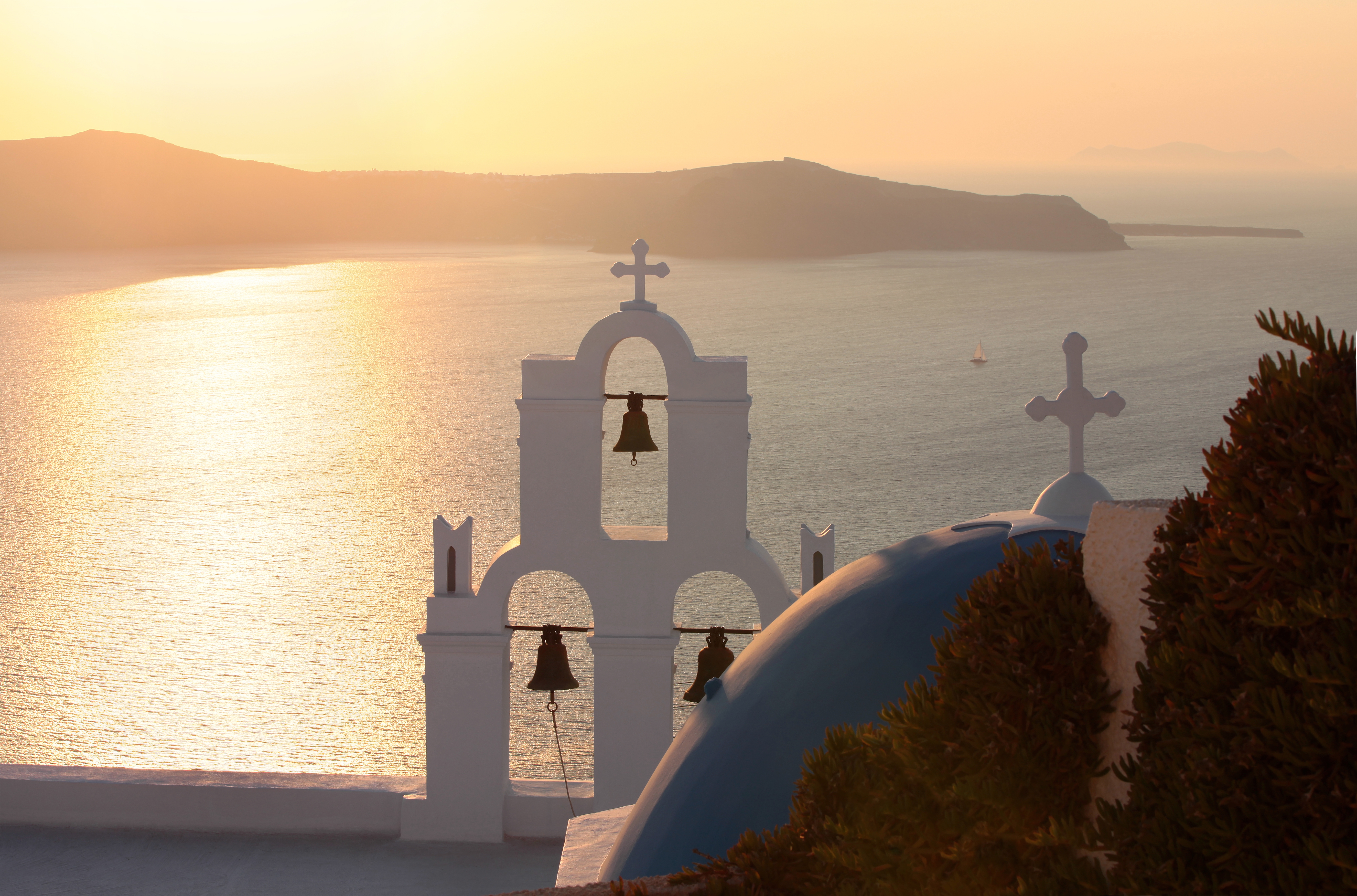 Vy över solnedgången och havet med vit kyrka på klippan i Santorini