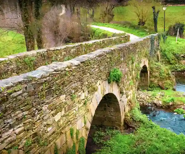 Den middelalderlige romerske bro Puente Romano uden for Sarria i Galicien