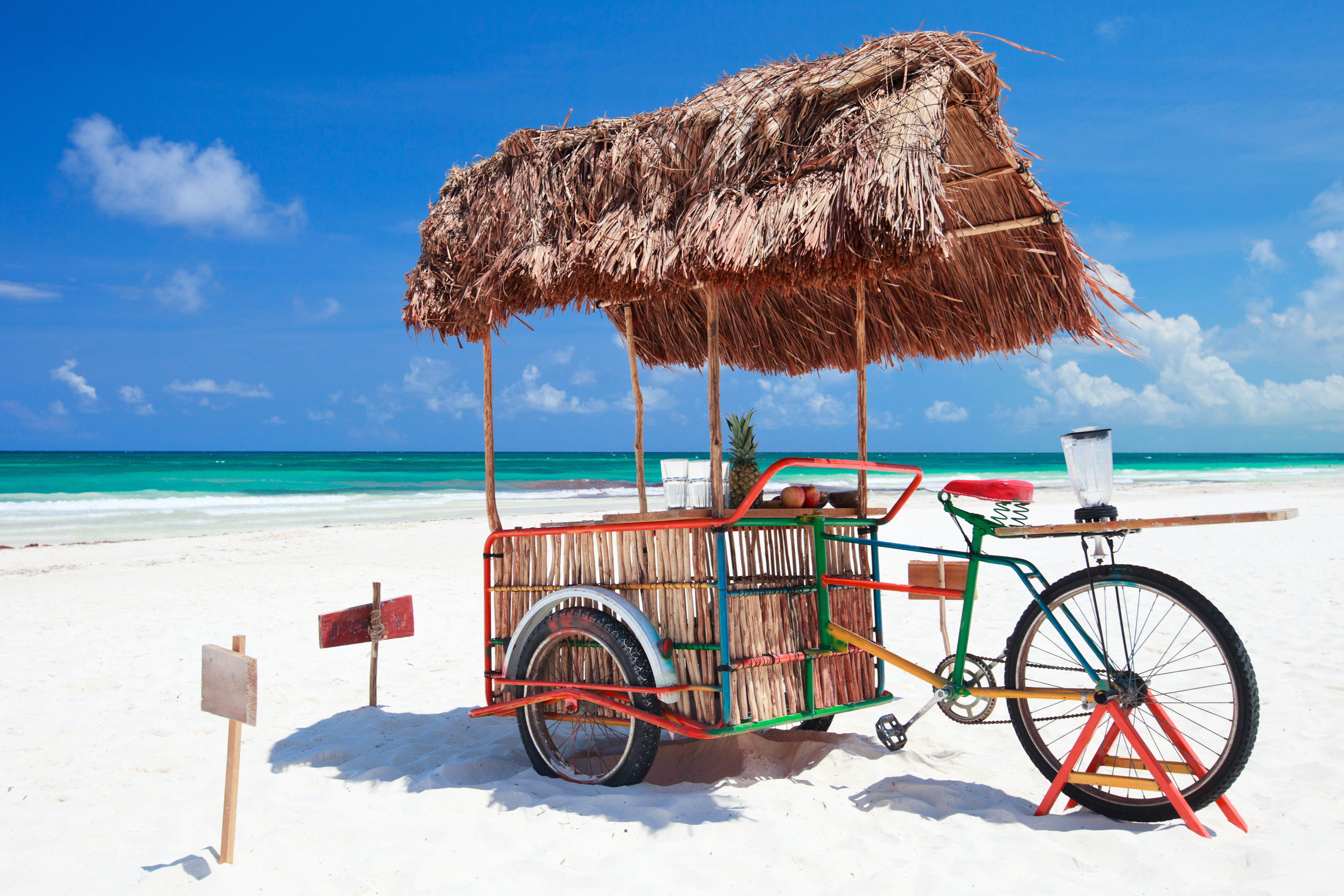 En cykel står på stranden med havet och sanden i bakgrunden.