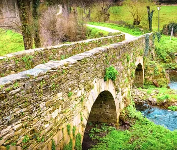 Den middelalderlige romerske bro Puente Romano uden for Sarria i Galicien