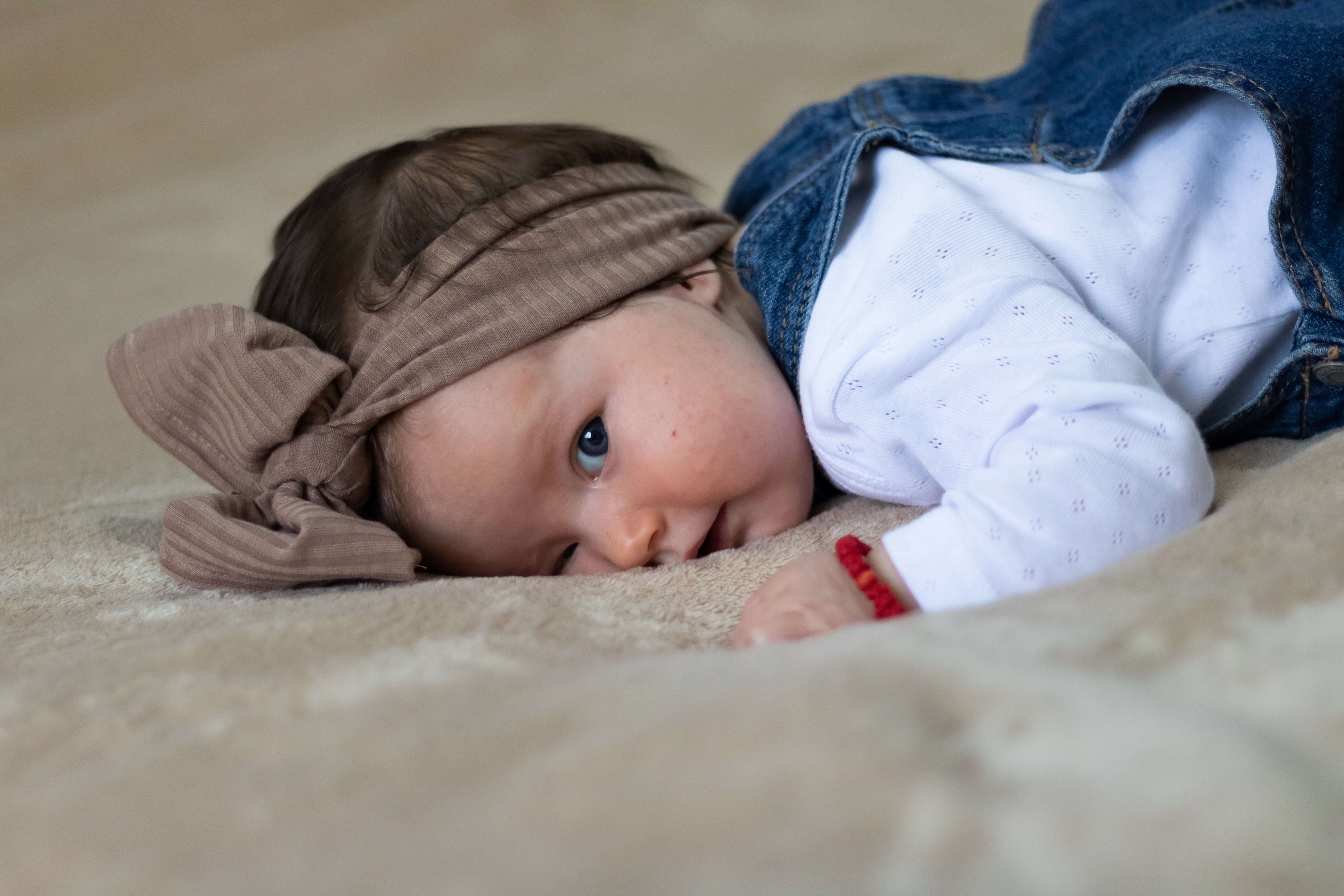 Nærbillede af en sød baby med turban, der ligger i sengen