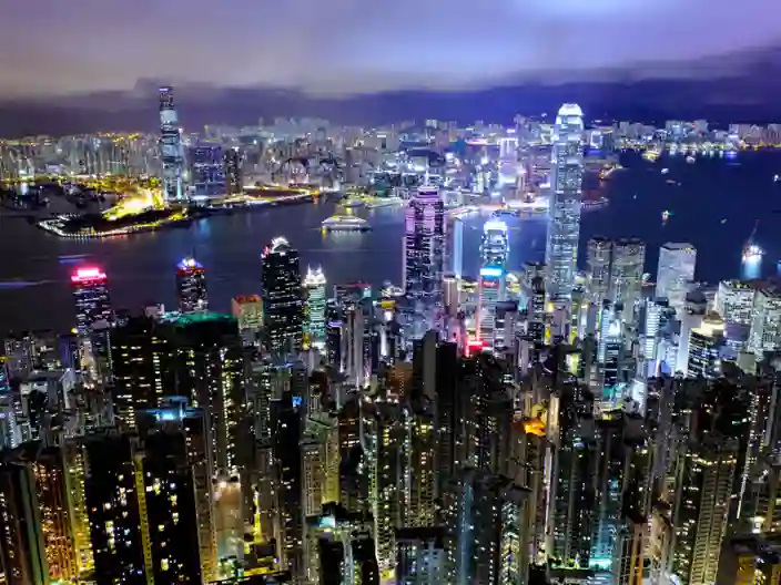 Stadens skyline lyser upp över Victoria Harbour när mörkret faller.