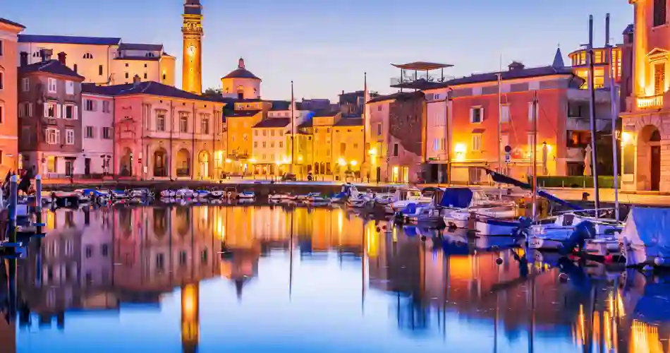 Hamnen i Piran i Slovenien vackert upplyst på kvällen